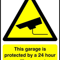 This garage is protected by a 24 hour surveillance system sign