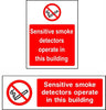 Sensitive smoke detectors operate in this building sign